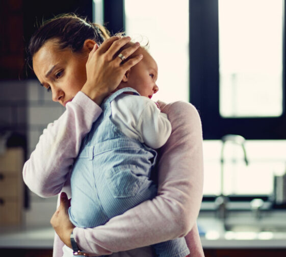 Affectionate mother consoling her baby at home.